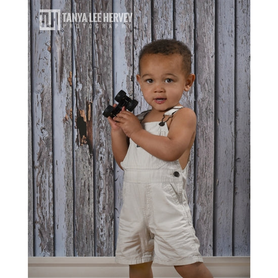 Boy posing in front of wood backdrop