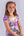 White backdrop little girl model sitting on  posing stool